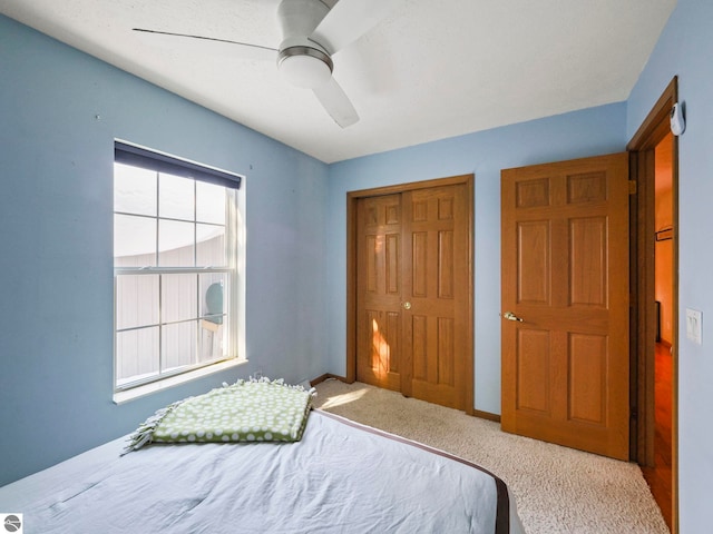 bedroom with carpet floors, a closet, baseboards, and a ceiling fan