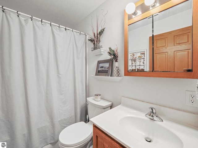 bathroom featuring curtained shower, vanity, and toilet