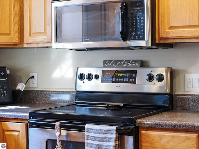 kitchen with stainless steel appliances and dark countertops