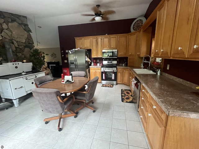 kitchen with light tile patterned floors, a ceiling fan, appliances with stainless steel finishes, and a sink