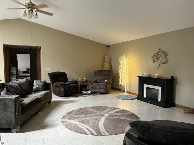 living room featuring baseboards, a ceiling fan, tile patterned floors, vaulted ceiling, and a fireplace