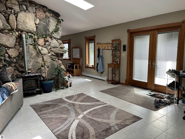 foyer with french doors, a baseboard radiator, tile patterned flooring, and a wood stove