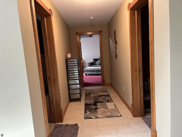 hall with baseboards and light tile patterned floors