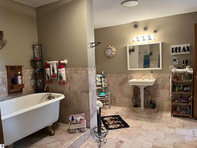 bathroom featuring a freestanding bath, wainscoting, and tile walls