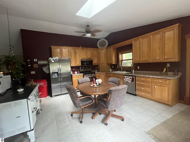 kitchen featuring ceiling fan, appliances with stainless steel finishes, a sink, and light tile patterned flooring