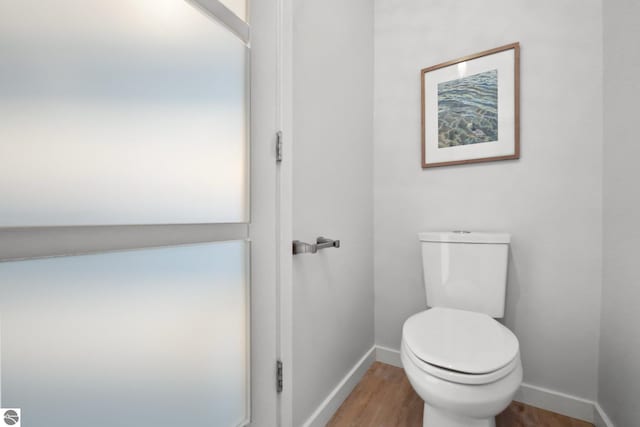 bathroom featuring baseboards, toilet, and wood finished floors