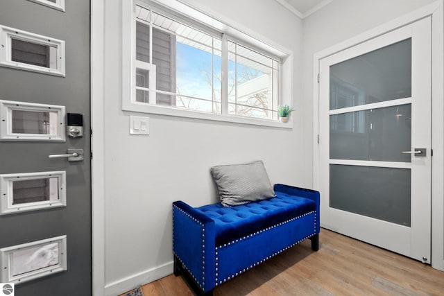 sitting room featuring crown molding, baseboards, and wood finished floors