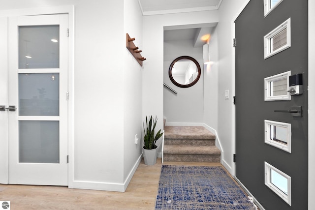 entrance foyer with light wood-style flooring, stairway, and baseboards