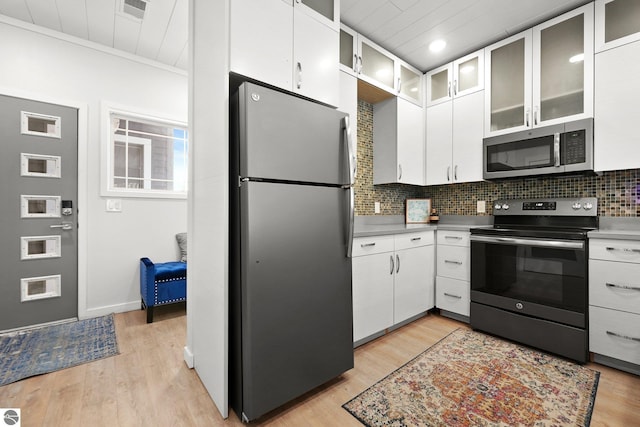 kitchen with white cabinetry, light wood-style floors, tasteful backsplash, and appliances with stainless steel finishes