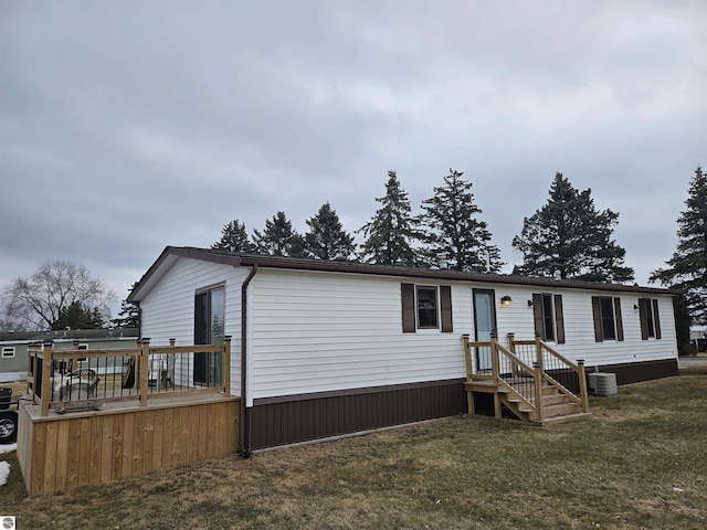 manufactured / mobile home featuring central AC and a front lawn