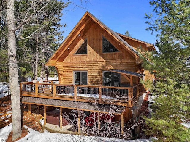 rear view of property featuring log siding and a deck