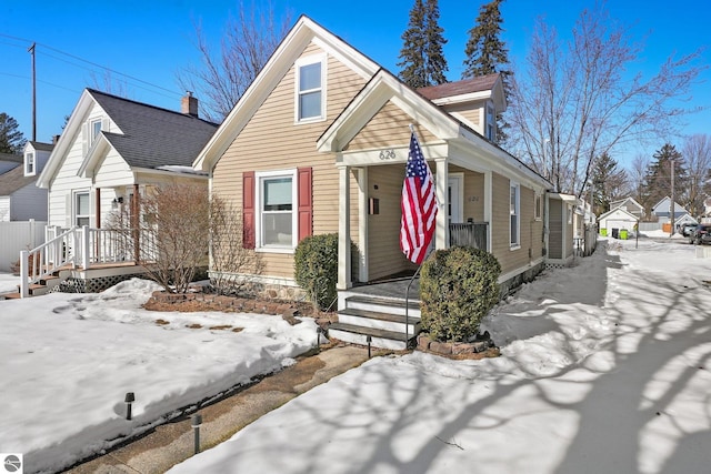 view of front of property with a porch and roof with shingles