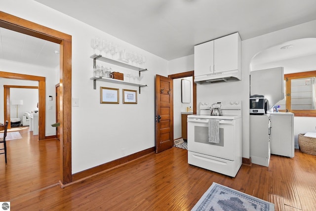 kitchen featuring white electric range, wood finished floors, white cabinetry, and under cabinet range hood