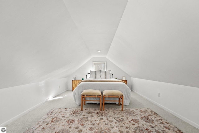 carpeted bedroom featuring lofted ceiling and baseboards