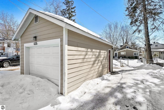 snow covered garage with a garage