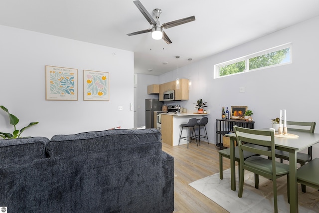 living room featuring a ceiling fan and light wood-style floors