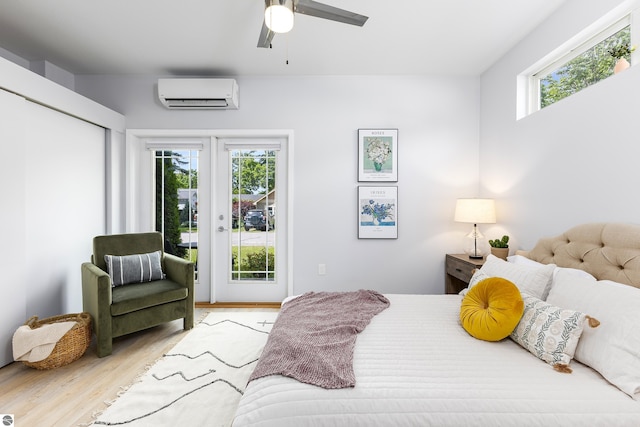 bedroom with access to outside, multiple windows, wood finished floors, and a wall mounted air conditioner