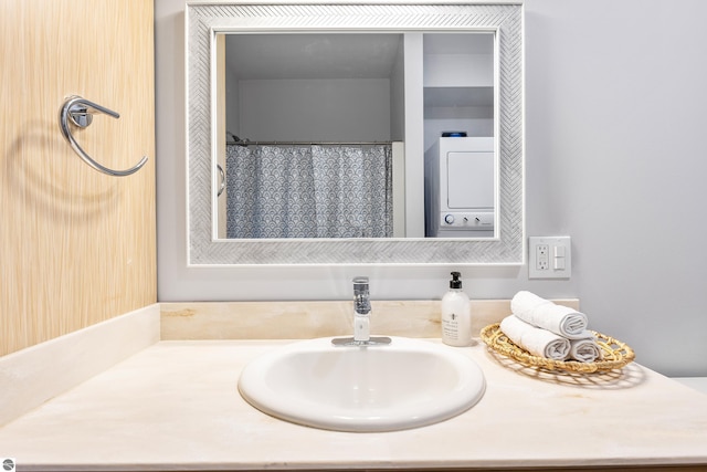 full bathroom featuring vanity and stacked washing maching and dryer