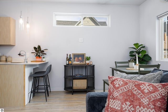 living area with light wood-style flooring and baseboards