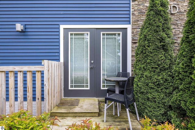 view of exterior entry featuring stone siding and french doors