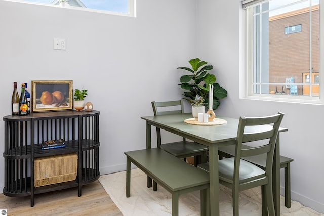 dining space with baseboards and wood finished floors