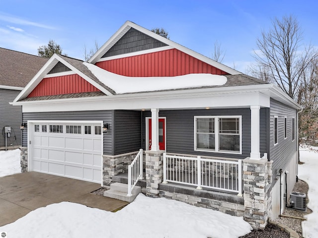 craftsman inspired home featuring central air condition unit, a porch, an attached garage, board and batten siding, and stone siding