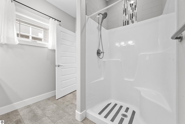 bathroom featuring a shower stall and baseboards