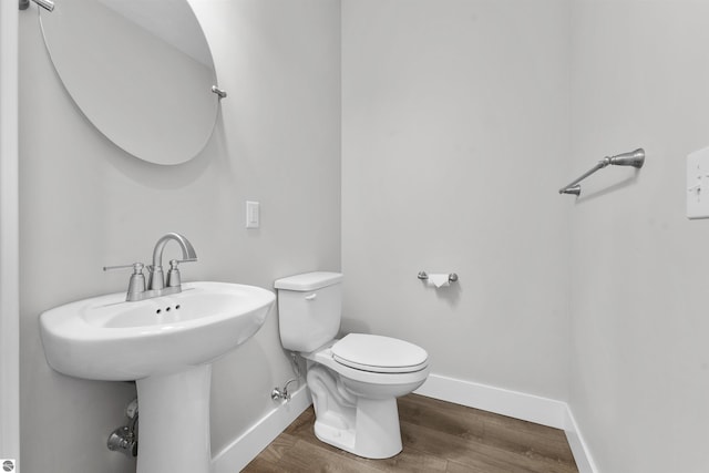 bathroom featuring baseboards, toilet, and wood finished floors