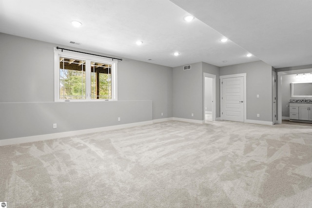 spare room with baseboards, recessed lighting, visible vents, and light colored carpet