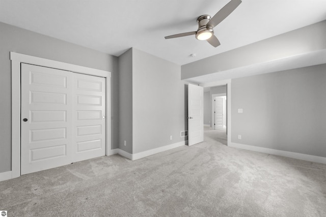 unfurnished bedroom featuring carpet floors, a closet, ceiling fan, and baseboards