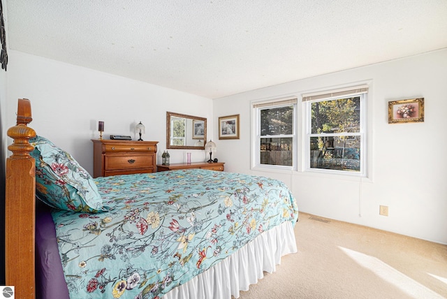 carpeted bedroom with a textured ceiling and visible vents