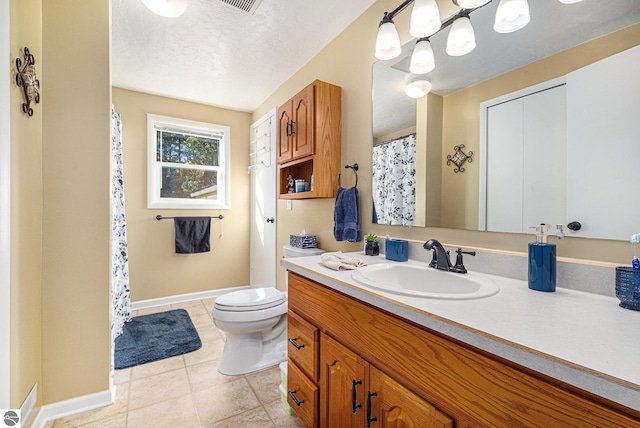 full bathroom featuring a textured ceiling, toilet, vanity, baseboards, and tile patterned floors