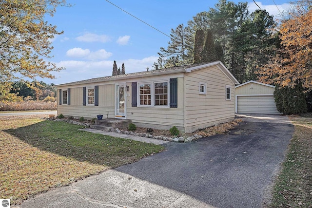 view of front of property featuring an outbuilding, a front lawn, and a garage