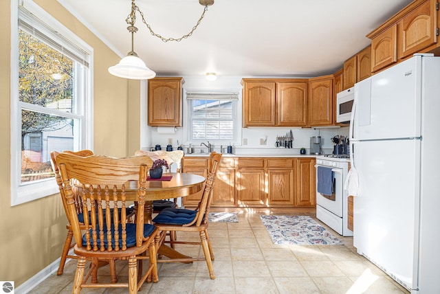 kitchen featuring white appliances, light tile patterned floors, baseboards, brown cabinets, and light countertops