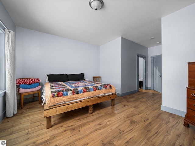 bedroom featuring wood finished floors and baseboards