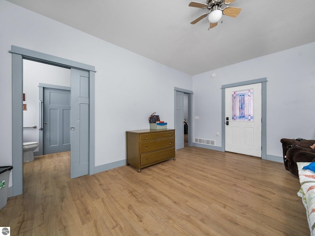 bedroom featuring visible vents, light wood-style flooring, baseboards, and two closets