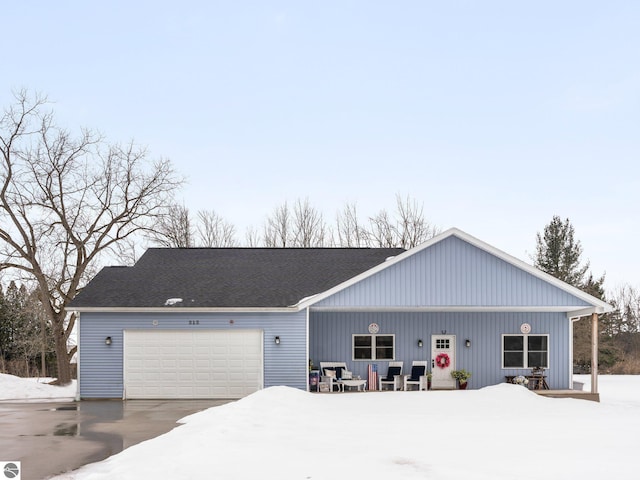view of front of house with a garage, driveway, and a shingled roof