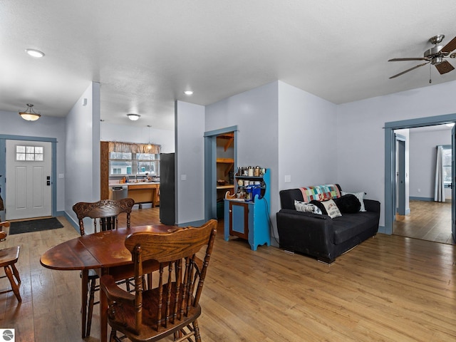 dining area with light wood-style floors and a ceiling fan