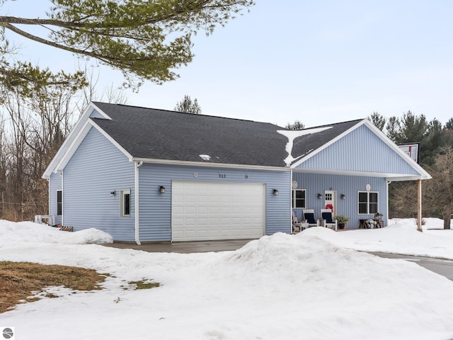 view of front of property featuring a garage and a shingled roof