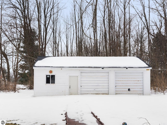 snow covered garage with a garage