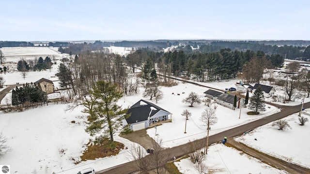 snowy aerial view featuring a forest view