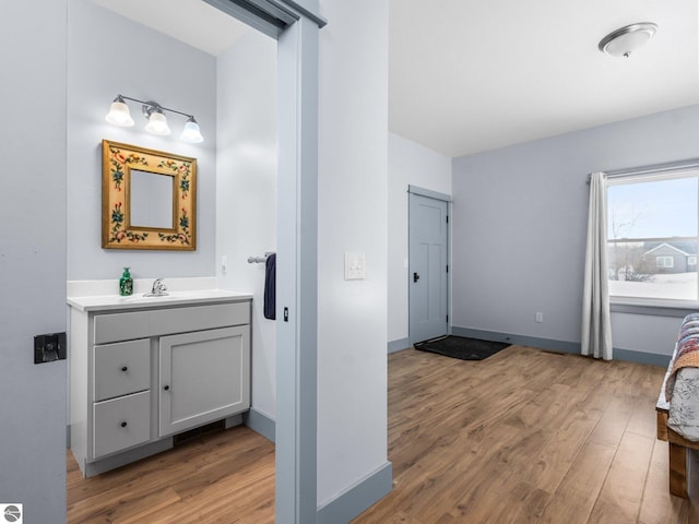 bathroom featuring baseboards, wood finished floors, and vanity