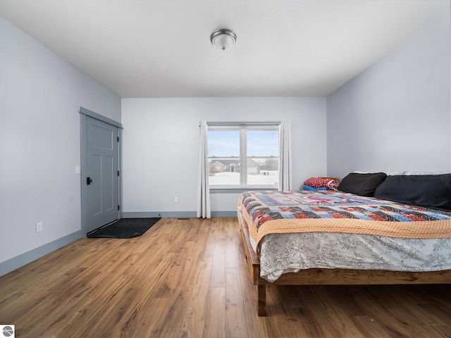 bedroom featuring baseboards and hardwood / wood-style flooring