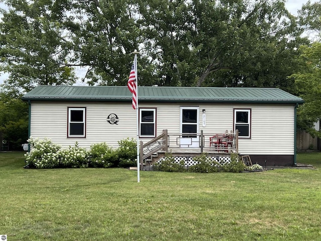 manufactured / mobile home featuring a front lawn, metal roof, and a wooden deck