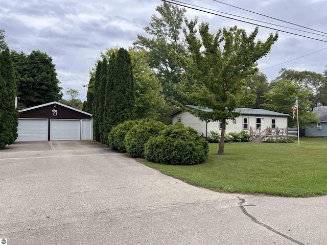 exterior space with an outdoor structure, a detached garage, and a front lawn