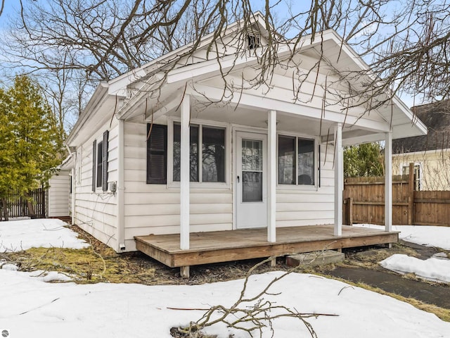 view of front of home featuring a porch and fence