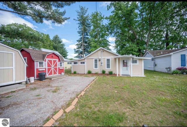 back of house with a storage unit, a lawn, and an outbuilding