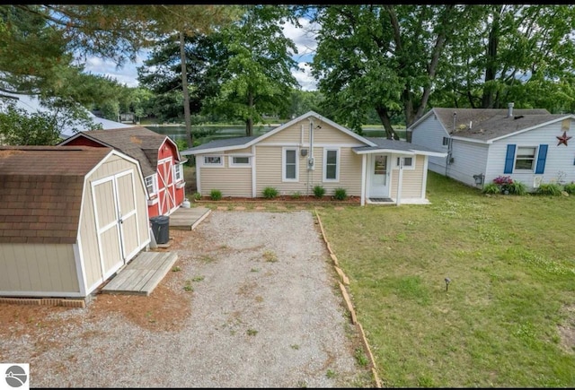 view of front of house with an outbuilding, a front lawn, and a shed