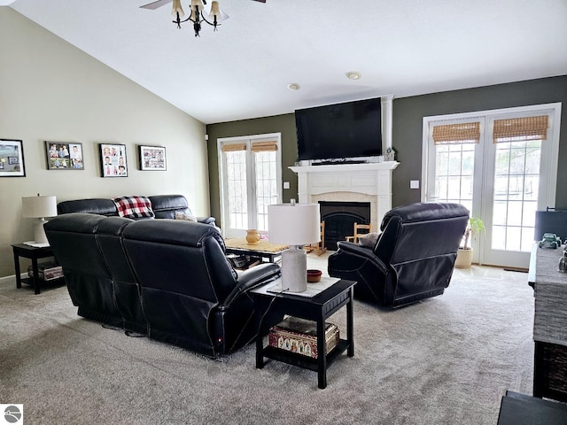 living room with a fireplace, lofted ceiling, light carpet, ceiling fan, and baseboards