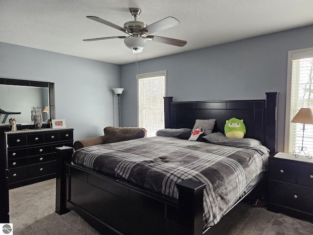 bedroom featuring carpet floors, a textured ceiling, and a ceiling fan